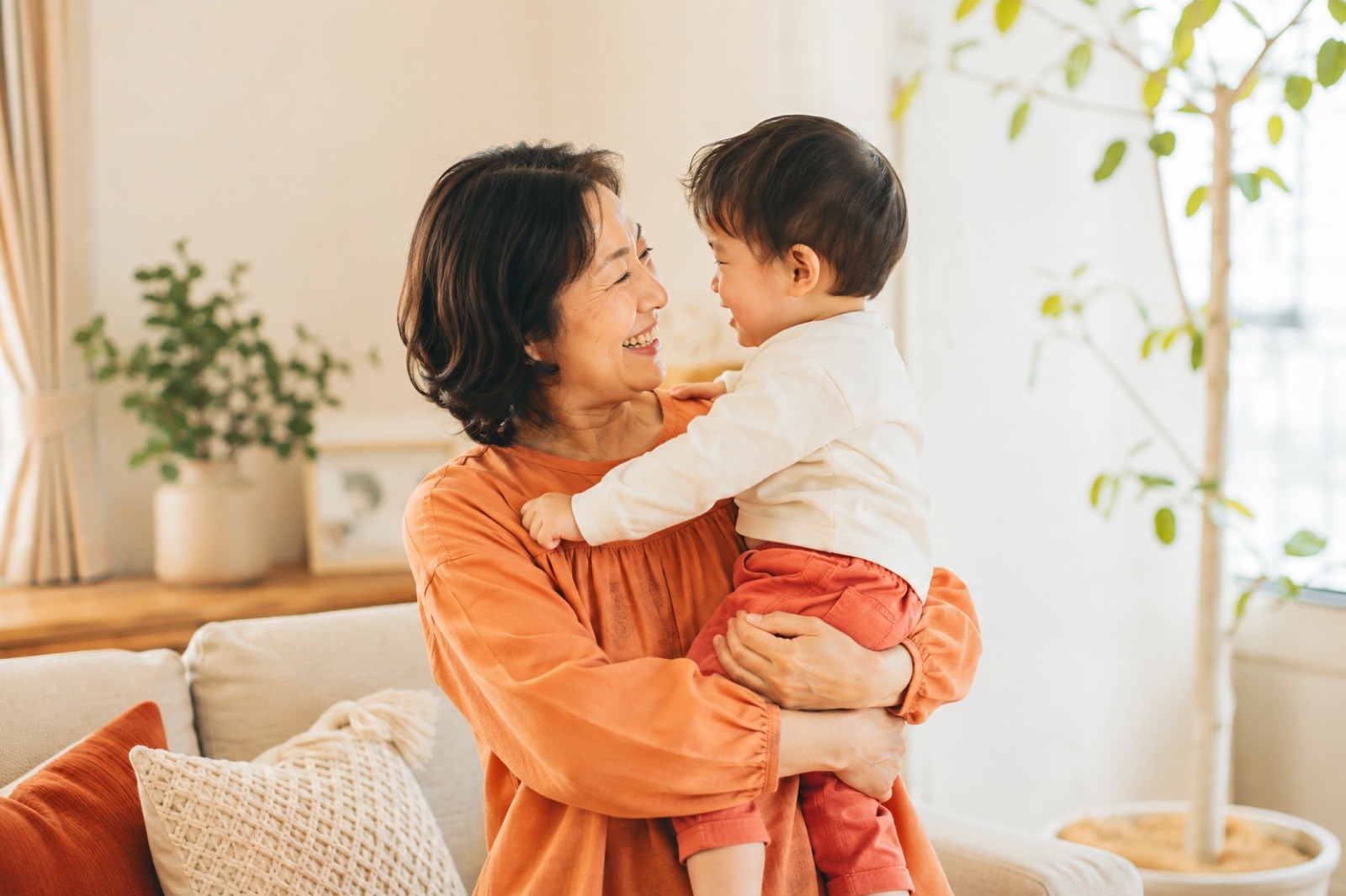 孫を抱っこする50代女性のイメージ