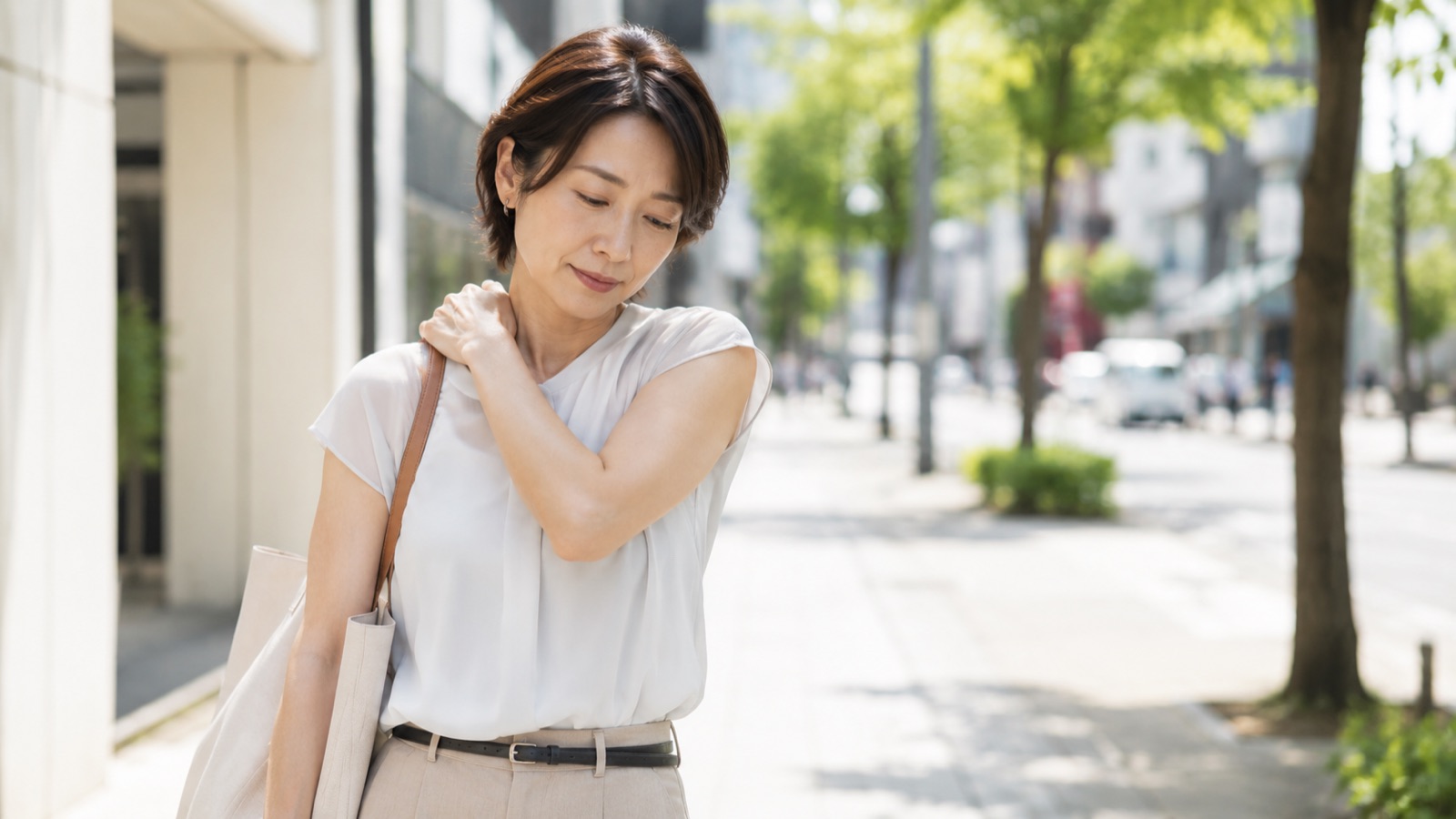 いつも同じ肩にバッグをかけて立つ40代女性のイメージ